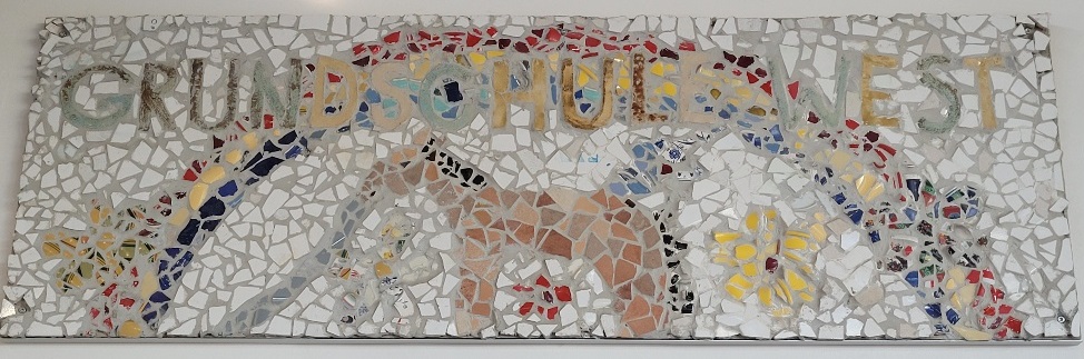 Schriftzug der Grundschule West auf einer Mosaik-Steintafel
